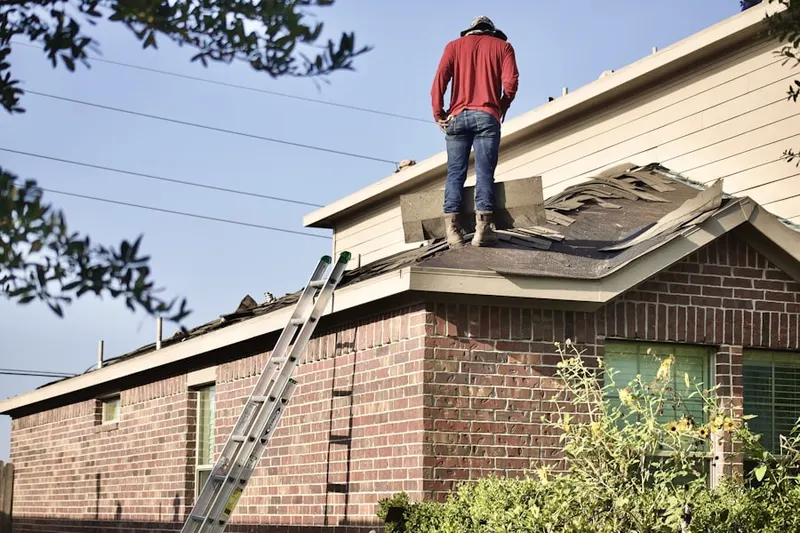 Professional roofer working on a residential roof in Weimer